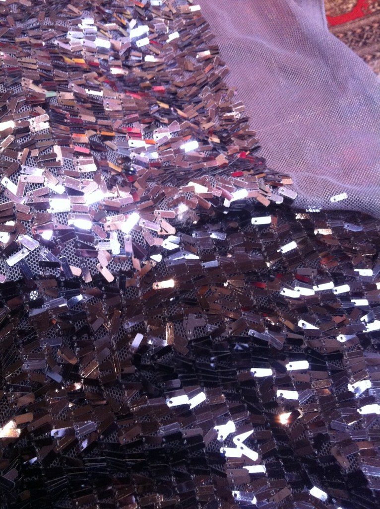 This fabric comes in 2 - black and charcoal. The little rectangles are sewn onto the mesh at one end and left to dangle, so you get a bit of swishy-ness!